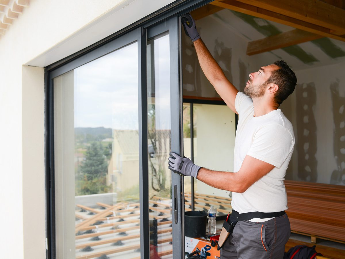 your man installing window to make home sustaniable